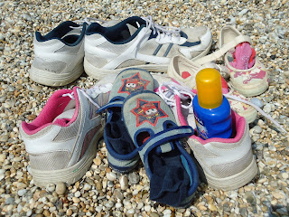 The whole families shoes on the shingle beach at Durdle Door