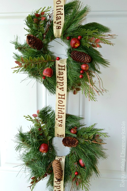 Two wreaths for Christmas on a white painted front door