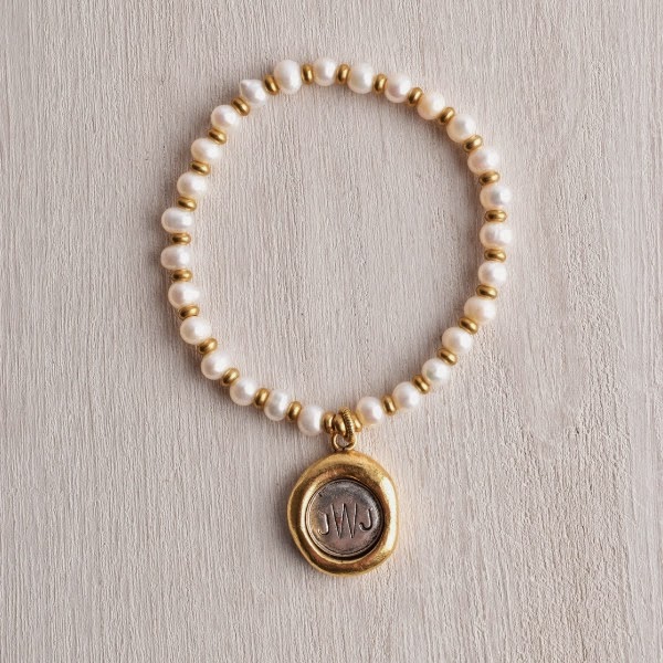 http://www.whitetrufflestudio.com/collections/bracelets/products/monogram-seal-charm-pearl-bracelet