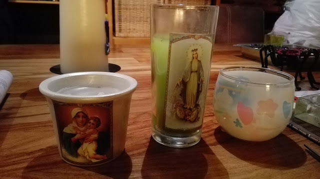 Diverse zelfgemaakte kaarsen, onder andere met Maria-afbeelding.