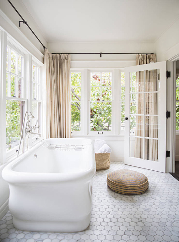 Bathroom spacious enough to accommodate a freestanding bathtub in a separate room filled with large openingsImage by Brittany Ambridge via Domino
