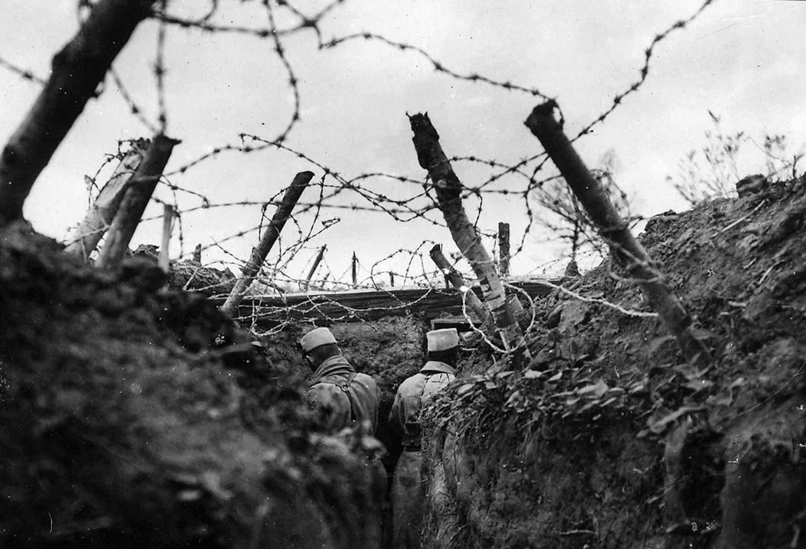 French lookouts posted in a barbed-wire-covered trench. The use of barbed wire in warfare was recent, having only been used for the first time in limited form during the Spanish-American War. All sides in World War I used extensive networks of barbed wire entanglements to prevent ground troops from moving forward. The effectiveness of the wire drove the development of technologies like the tank, and wire-cutting explosive shells set to detonate the instant they made contact with a wire.