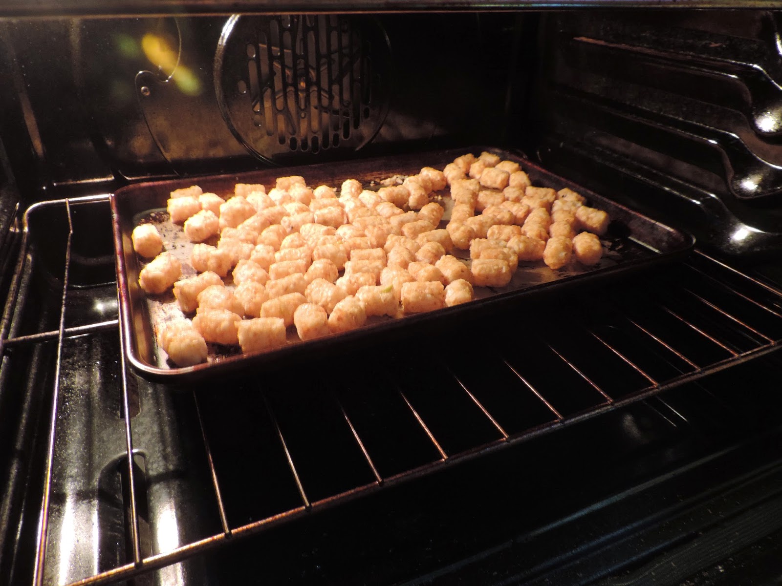 Tater tots cooking in the oven. 