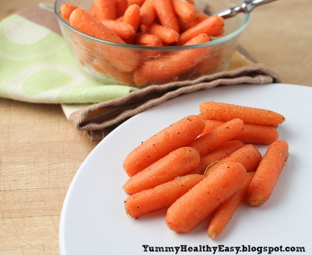 A plate with a scoop of cooked carrots and a bowl of cooked carrots behind it.