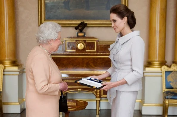 Actress Angelina Jolie is presented with the Insignia of an Honorary Dame Grand Cross of the Most Distinguished Order of St Michael and St George by Queen Elizabeth II in the 1844 Room on 10.10.2014 at Buckingham Palace