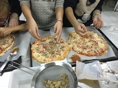la imagen muestra dos pizzas terminadas por los niños