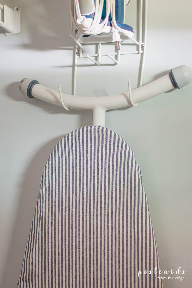 See how she gave her laundry room a cute makeover for less than $100, including this cute ironing board cover!