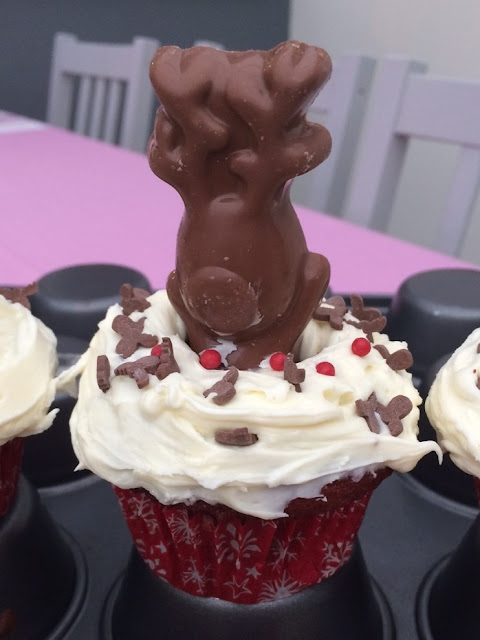 Red velvet cup cakes with sprinkles and a chocolate reindeer