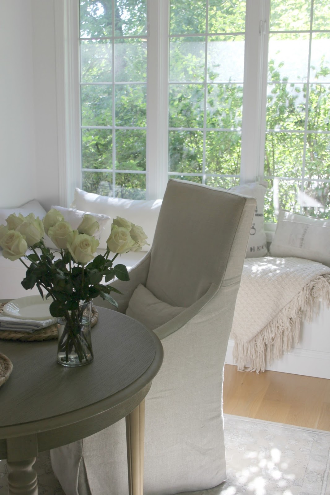 Serene white breakfast nook with window seat. A mix of old and new, a relaxed approach to decor and shopping, and plenty of creativity yield a timeless look that isn't dependent on following trends or disposable decor. Come read more practical decor advice from Hello Lovely.
