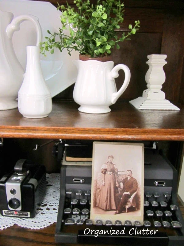 Cameras, Ironstone, & Typewriter Displayed in China Cabinet www.organizedclutterqueen.blogspot.com