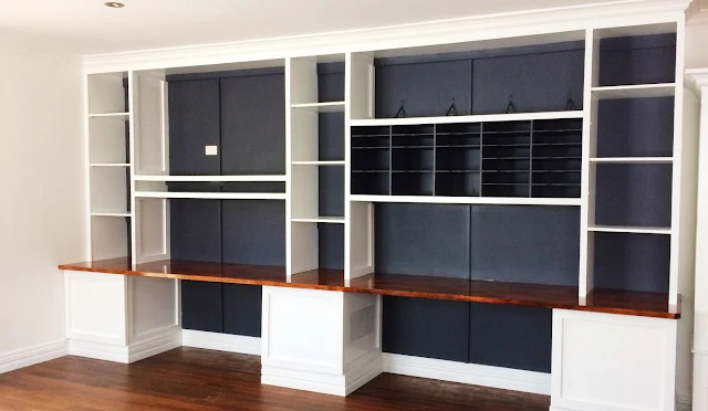 large wall of built ins with desk