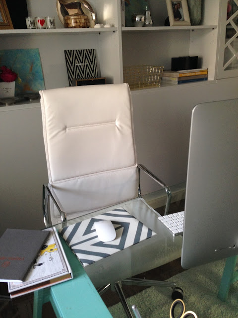 Home office picture with desk, chair and shelves.