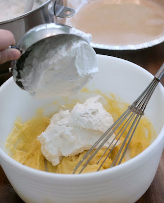 Putting whipped cream into a mixing bowl with pudding mixture