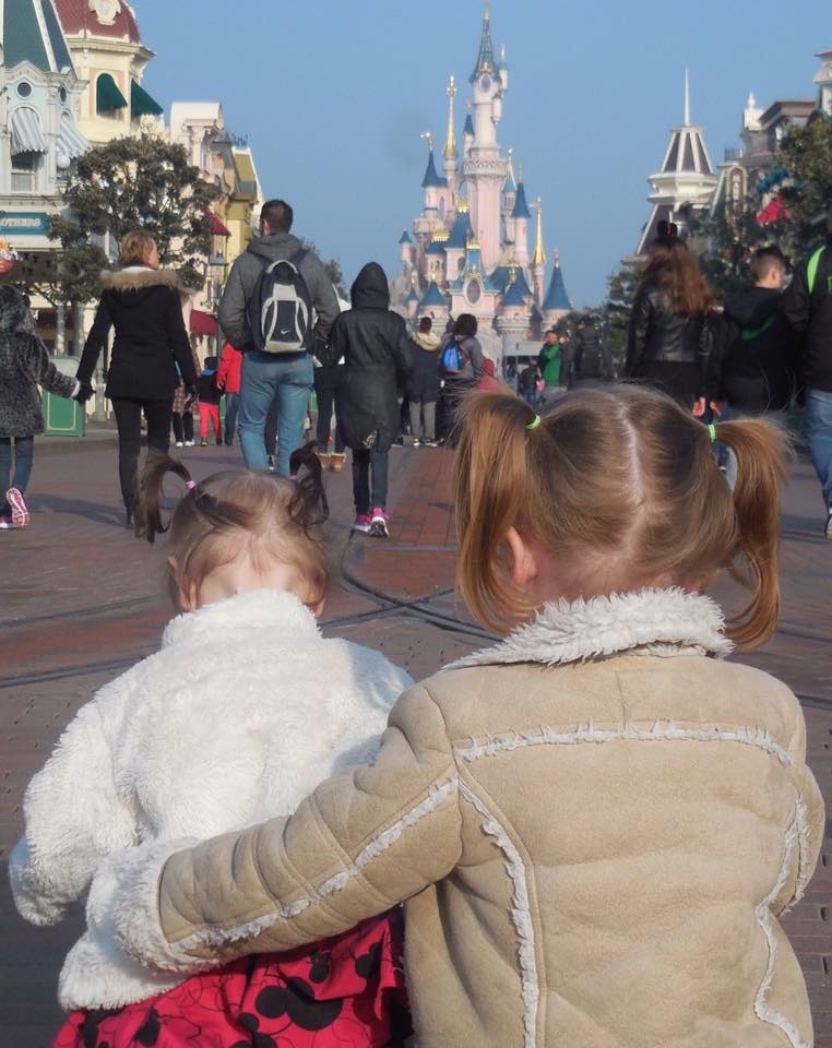 Toddlers sitting in front of Disneyland Paris Castle