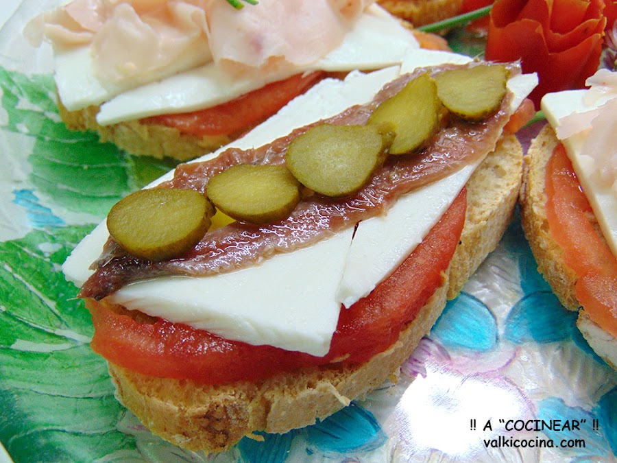 Montaditos o tostas de queso fresco con anchoas y pavo