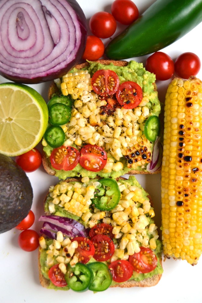 Grilled Corn Avocado Toast features mashed avocado with garlic and lime juice on toast with grilled corn, sliced tomatoes, jalapenos and red onion for a delicious meal or snack! www.nutritionistreviews.com