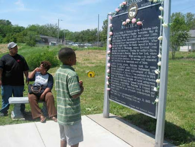 Photo of the Malcolm X birthplace plaque with preteen boy reading it