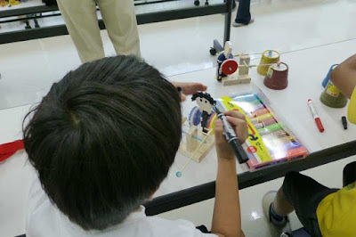 人形に顔を描く子供