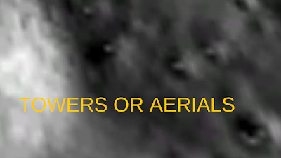 Towers or aerials on the Moon sticking out of craters.