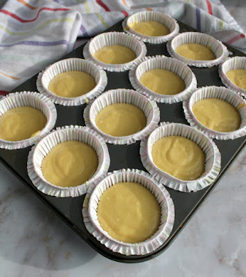 yellow cupcake batter in cupcake liners ready to bake