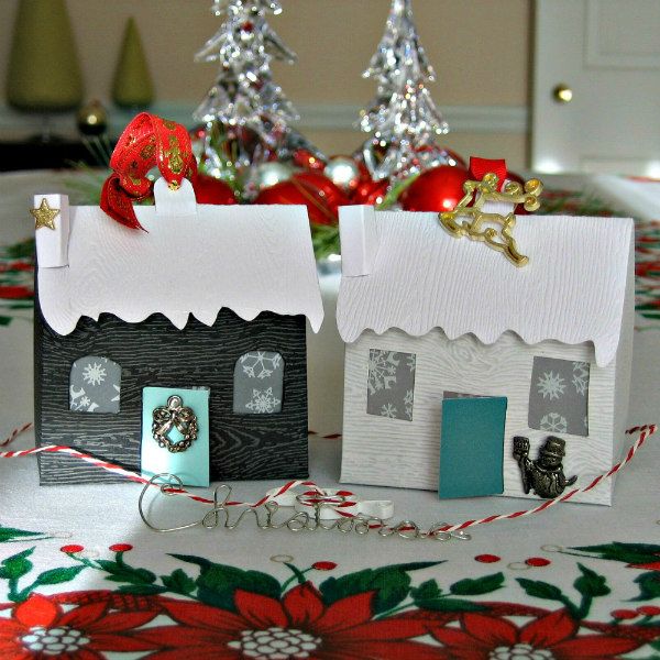 pair of tiny houses made of wood grain card stock with holiday trimmings