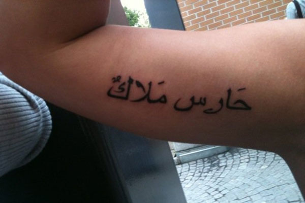 chica con tatuaje arabe en el biceps