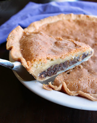 first slice of toll house pie with gooey chocolate and brown sugar layers being raised from pie