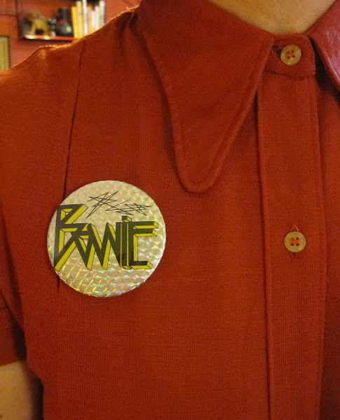 Addicted to brooches and badges : orange arrow brooch , vintage spool of thread brooch , vintage Buzzcocks badge and  vintage Bowie pinback button .   1950 1960 1970 50s 60s 70s pin button punk david bowie ziggy stardust