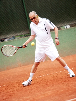 Persona mayor jugando tenis Foto de un hombre de tercera edad jugando tenis
