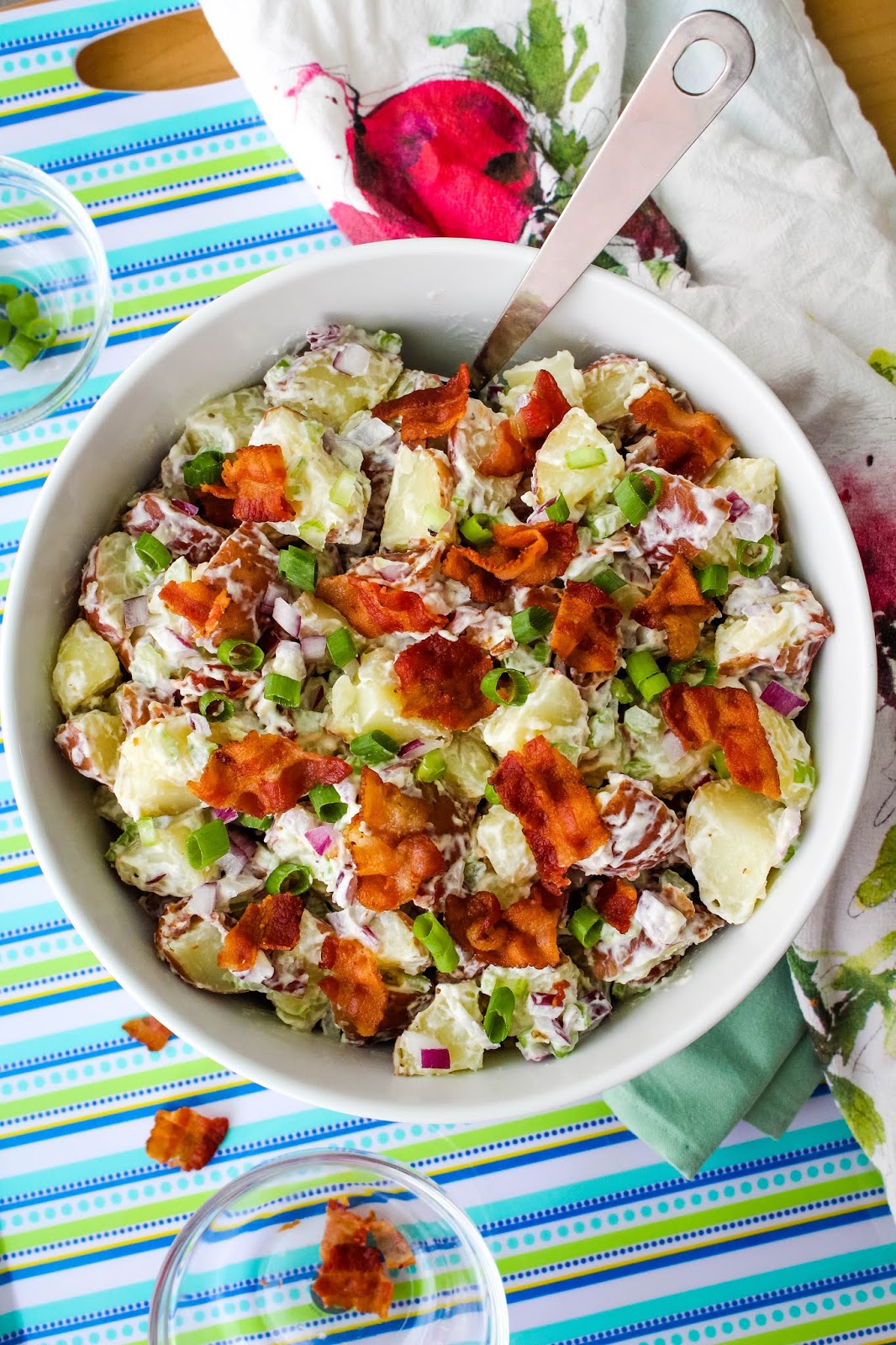 Red Potato Salad with Bacon is made with a cool and creamy mayo-sour cream mixture and tons of crumbled bacon. This simple side dish is perfect for barbecues, parties, and tailgating! #potatosalad #sidedish #bacon