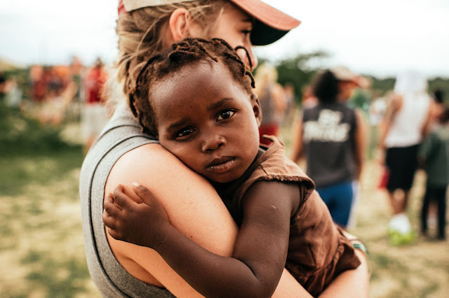 Women holding a sad orphan child