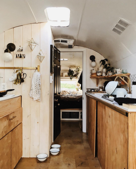 natural wood, honeycomb backsplash tile pattern, and a lot of plants filled this tiny kitchen vintage airstream