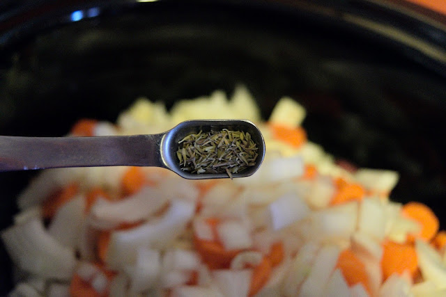 Dried Thyme being added to the crock pot. 