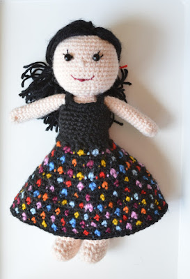 Kwokkie Doll in an outfit of 'Dotty Daywear': a black sleeveless top and a black skirt covered in brightly-coloured polka-dots.