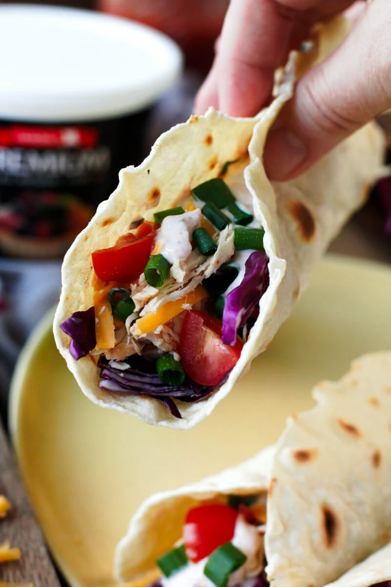 Slow Cooker Salsa Ranch Chicken Tacos are made by topping easy-to-make homemade tortillas with 3-ingredient shredded chicken, fresh veggies, and a cool greek yogurt salsa ranch.  Your family will fall in love with this crockpot dinner recipe! #ArmourPremiumLard #Pmedia #ad @walmart