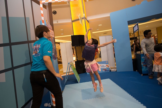 Kid jumps high to catch the star at 'Tall' booth