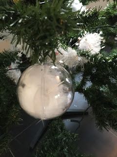Boule de Noël à plumes DIY accrochée sur le sapin de Noël