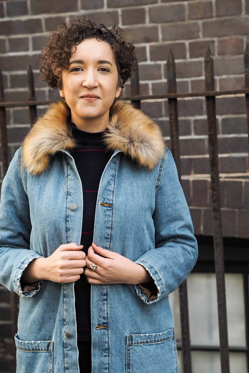Fashion blogger wears long denim coat with faux fur collar