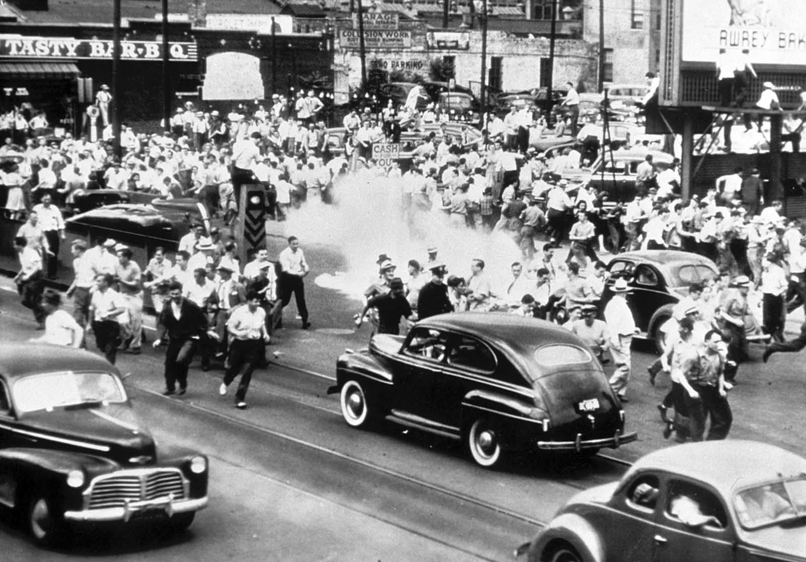 Police use tear gas to disperse a crowd gathered on the main street of Detroit, Michigan, in an effort to halt race rioting on June 21, 1943.