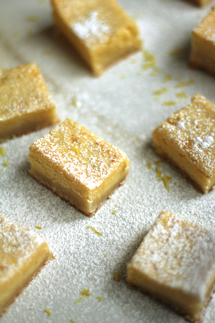 Several lemon brookies topped with powdered sugar and lemon zest.