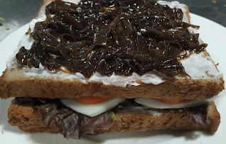 Caramelized onions spread over layered bread slices for veg club sandwich recipe