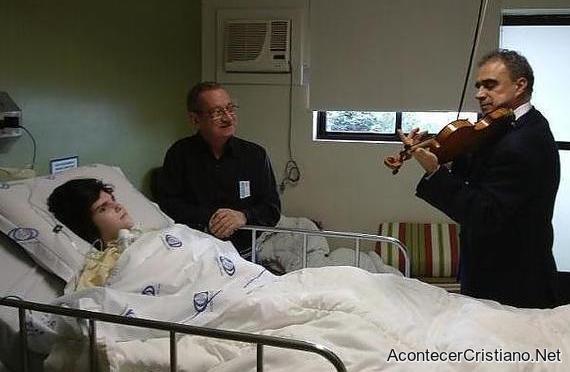 Violinista tocando melodías ante un enfermo en hospital