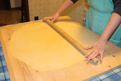 Mama Isa rolls the fresh pasta with a rolling pin