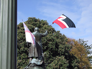A statue of Richard Seddon with a Tino Rangatiratanga flag and a flag of the United Tribes