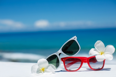 two pairs of sunglasses on the beach