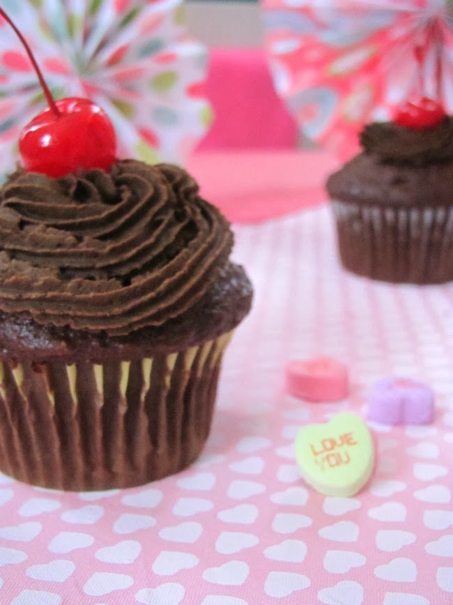 chocolate cupcake with chocolate frosting and a cherry