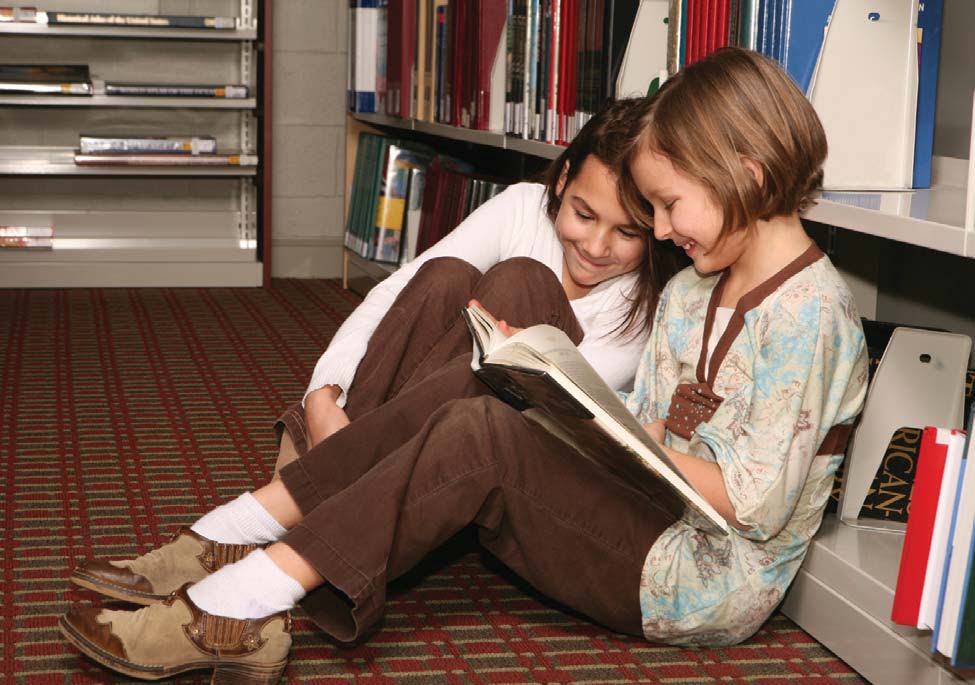 NAMC Montessori teachers first week of successful elementary school year girls reading book in library together