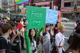 young women hold signs that say free hug and LGBT at 2011 Taiwan LGBT Pride Parade