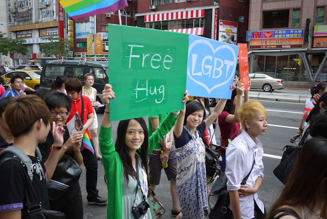 young women hold signs that say free hug and LGBT at 2011 Taiwan LGBT Pride Parade