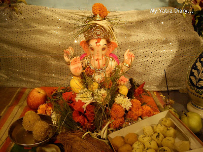 Ganpati idol with modaks and ladoos and flowers